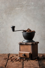 Old coffee grinder on wooden board
