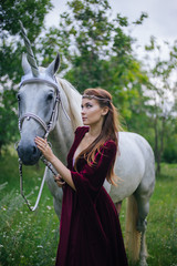 Beautiful girl in red medieval dress with unicorn. Fantasy. Woman Elf