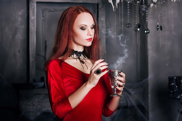 Beautiful red-haired girl with red lips. A model in a red dress with a black necklace in the...