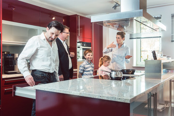 Expert explaining new kitchen to family looking for one 