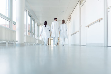 Three doctors walking down a corridor in hospital