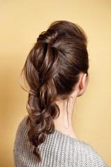 Fototapeta premium Rear view of female hairstyle volume braid with brown hair