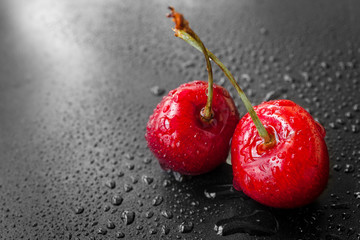Red cherry berries in water drops. Fresh cherries on dark background. Food background
