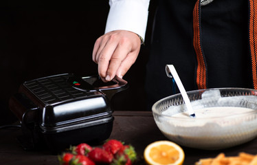 Man making waffles on a waffle machine