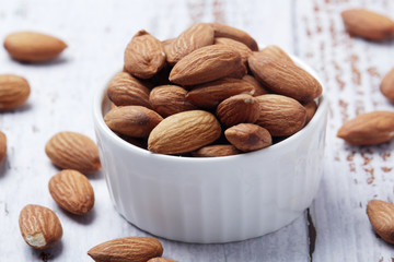 A small bowl with almond at white background