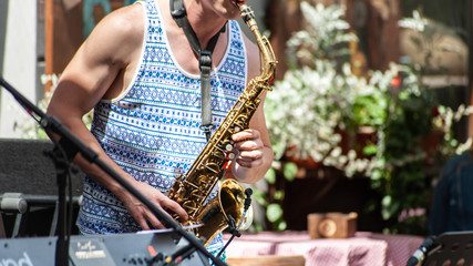 Street jazz by handsome saxophonist playing saxophone outdoor
