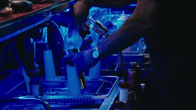 A bartender puts ice in a mixer.