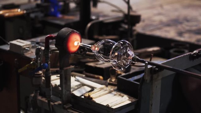 Glass maker works the glowing hot wine glass