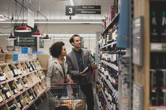 Couple choosing wine in grocery store