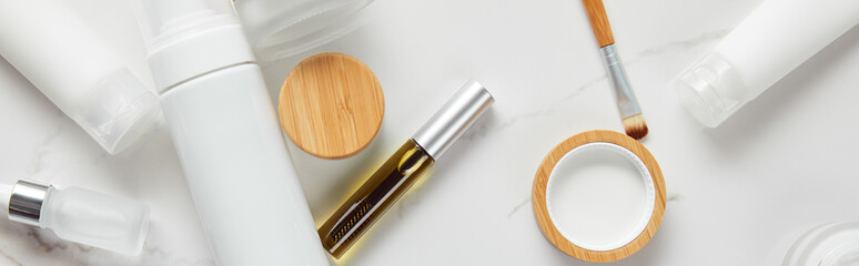 panoramic shot of cream tubes, cosmetics jars, dispenser, glass and mascara bottles with eye brush...