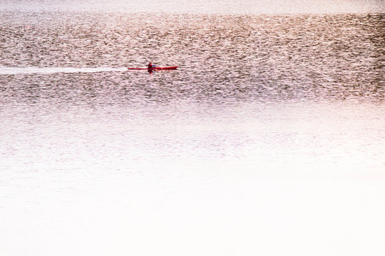 Single Red Kayak In Golden Shimmery Water