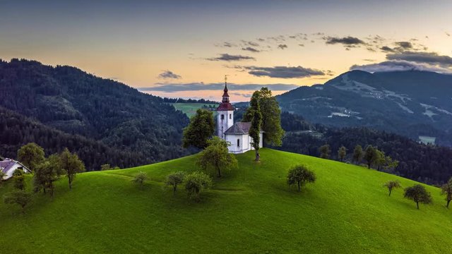 Skofja Loka, Slovenia - 4K aerial time-lapse (Hyperlapse) footage of flying by the small Sveti Tomaz (Saint Thomas) church at sunset at summer time