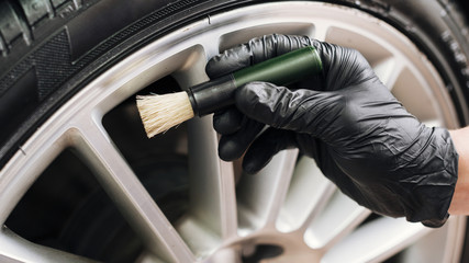 Fototapeta na wymiar Close up of man cleaning car rims