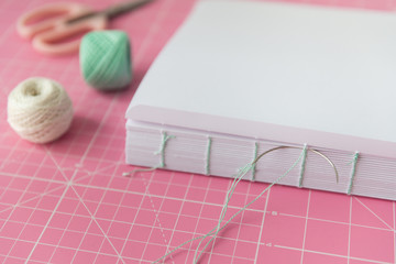 Book binding process. Threads, scissors and pages. Handmade coptic binding. Paper crafts,...
