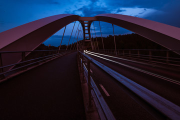 light trails of car on bridge at night
