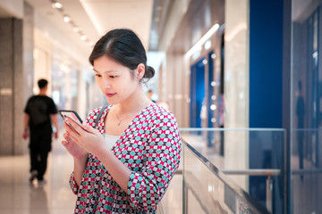 Woman using smartphone inside shopping mall