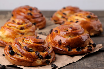 Tasty buns with raisins on a brown wooden table. fresh bakery. breakfast. bread. close-up