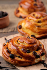 Tasty buns with raisins on a brown wooden table. fresh bakery. breakfast. bread. close-up