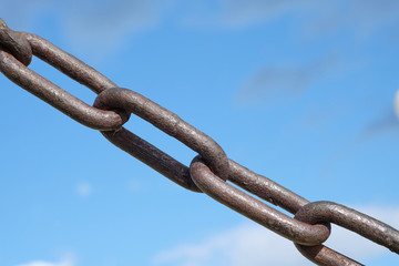 old rusty Chain against  cloudy sky