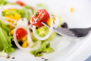 tomatoes onion mozzarella on fork