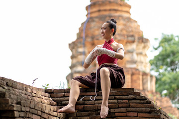 Close-up of a young woman Muay Thai fighter preparing and wrapping her hand with traditional hemp ropes before the fight or training.