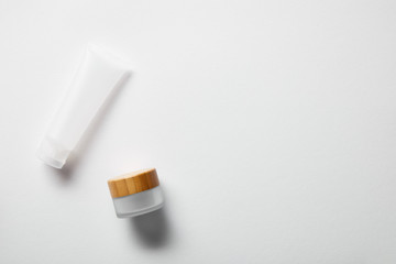 top view of cream tube and jar on white