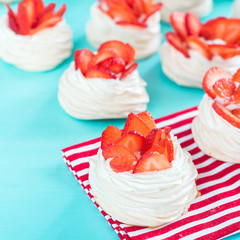 Beautiful pavlova cakes with strawberries on a blue background. Selective focus. Tasty sweet breackfast. Wedding morning. Meringue with cream.