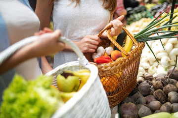 Young happy women shopping vegetables and fruits on the market