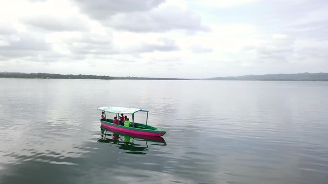 Aerial view of motor boat in the middle of a lake de atitlan. Exploring the lake with the people on the boat.