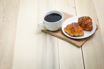 Croissant and coffee  isolated on wood table