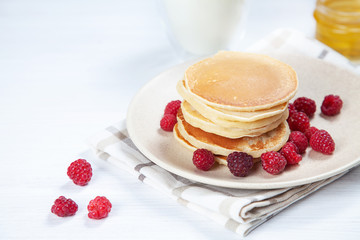 Closeup Pancakes with honey or marple syrup and berry for breakfast. Food for breakfast. Copy space for design. homemade american pancakes snack. pancake with glass of milk