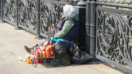 An elderly woman selling souvenirs on the Patriarshy Bridge, near the Cathedral of Christ the...