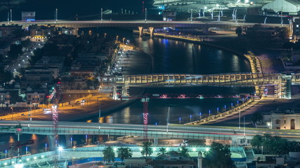 Fototapeta na wymiar Dubai water canal with footbridge aerial night timelapse from Downtown skyscrapers rooftop