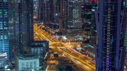 Aerial view of towers in Business Bay with traffic on the road night timelapse.