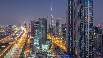Evening skyline with modern skyscrapers and traffic on sheikh zayed road day to night timelapse in Dubai, UAE.