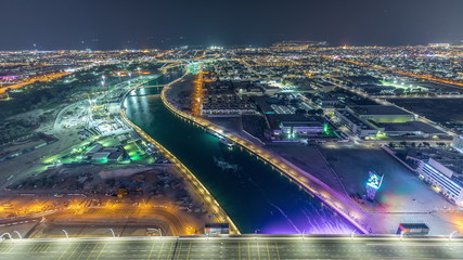 Dubai water canal with footbridge aerial night timelapse from Downtown skyscrapers rooftop