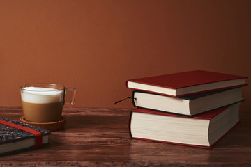  Coffee and books on a brown wooden table.