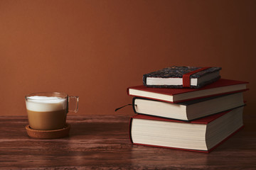  Coffee and books on a brown wooden table.