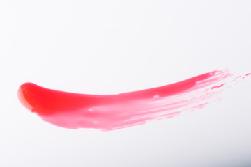 Obraz na płótnie Canvas Red nail varnish brush stroke on a white background.