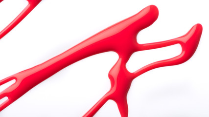 Vibrant red nail laquer spill on a white background.