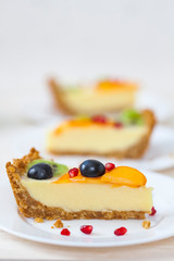 Several pieces of cake with fruit on white plates.