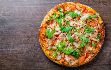 Pizza with Mozzarella cheese, salmon fish, tomato sauce, pepper. Italian pizza on wooden table background