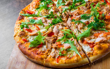 Pizza with Mozzarella cheese, salmon fish, tomato sauce, pepper. Italian pizza on wooden table background