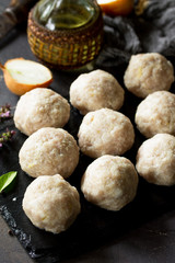Homemade turkey meatballs close-up raw on slate blackboard.