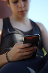 teenager watching the mobile during a break after training