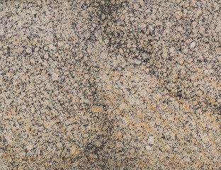 Close-up of a spotted light red or orange and black granite stone wall. High resolution full frame textured background.