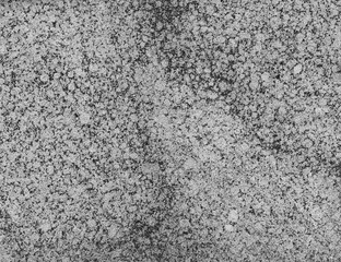 Close-up of a spotted granite stone wall in black and white. High resolution full frame textured background.