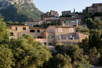 Obraz premium Beautiful view of old mountain village Deia in Mallorca on a sunny day. Deia traditional stone village in Majorca Tramuntana mountain