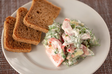 Green vegetables salad. Tomatoes, cucumbers, onions, parsley, fennel, sour cream, bread, sandwiches. A table in summer cafe.