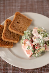 Green vegetables salad. Tomatoes, cucumbers, onions, parsley, fennel, sour cream, bread, sandwiches. A table in summer cafe.